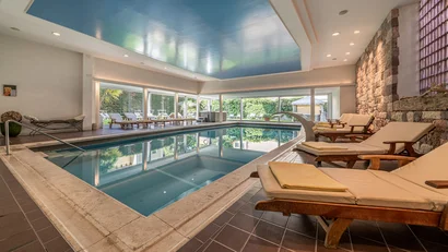 Indoor pool with lounge chairs in a relaxing setting
