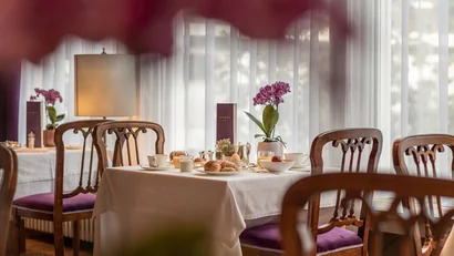 Breakfast table with croissants and orchid in elegant restaurant