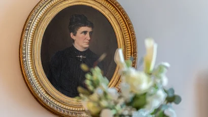 Oil painting of a woman with updo hairstyle in a golden oval frame