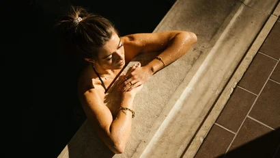 Woman relaxing at pool edge in sunlight
