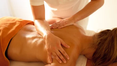 Woman receiving a back massage in a relaxing setting