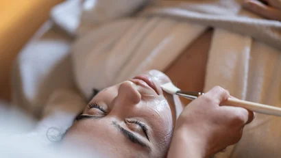 Woman receiving a facial mask application at a spa