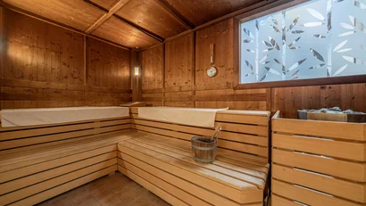 Interior of a traditional wooden sauna with bench and water bucket